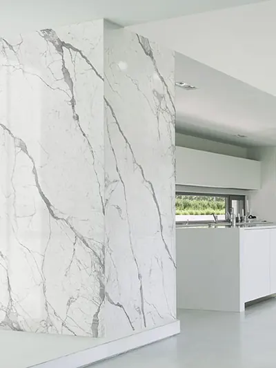 Parete rivestita con lastre effetto marmo Statuario in un ambiente bianco