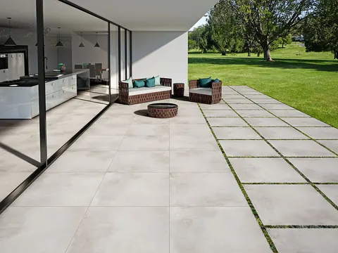 Portico e giardino con pavimento in gres effetto cemento chiaro
