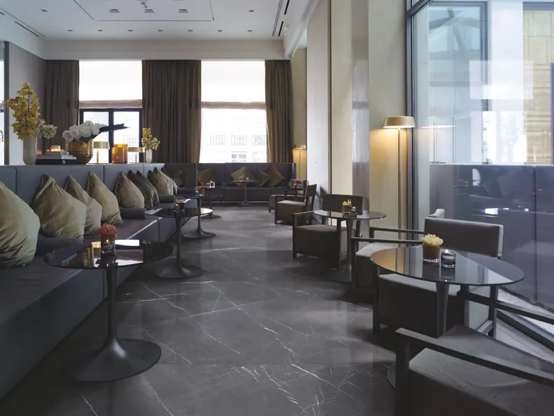 Lounge con ampio pavimento in gres effetto marmo grafite levigato